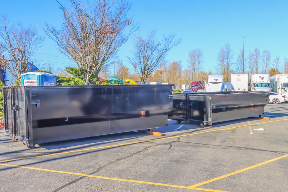 Professional dumpster rental service with roll-off container on residential driveway in Ames